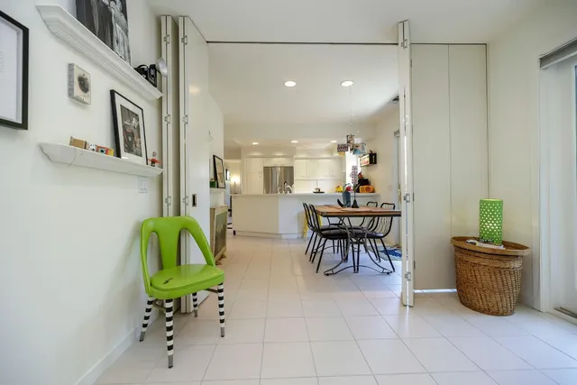 a dining area with a table chairs and a kitchen view