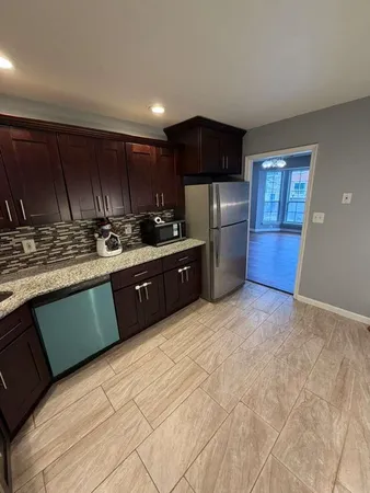 a kitchen with stainless steel appliances granite countertop a refrigerator a sink a stove a microwave and wooden cabinets