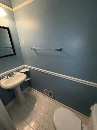 a bathroom with a sink a toilet and mirror
