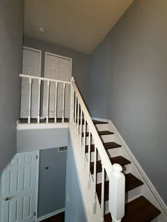 a view of staircase with lots of frames on wall and a window