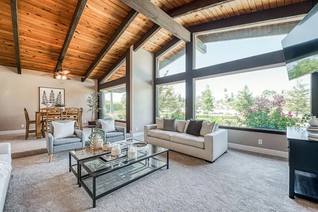 a dining room with furniture and large windows