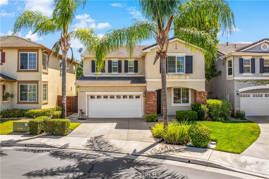 33307 Decada Street Temecula, CA 92592 - Photo 1 of 35 a front view of a house with a garden and palm trees