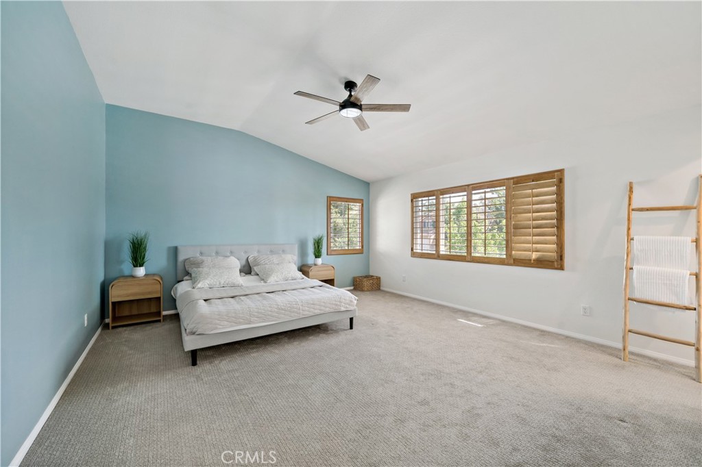 33307 Decada Street Temecula, CA 92592 - Photo 24 of 35 a spacious bedroom with a bed and a chandelier