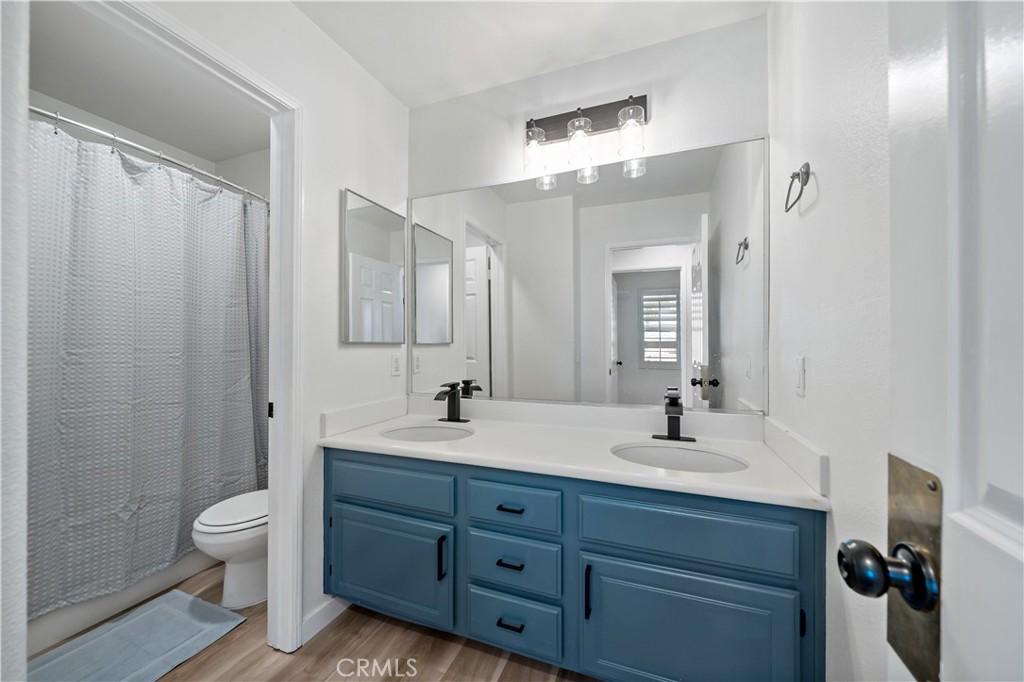 33307 Decada Street Temecula, CA 92592 - Photo 30 of 35 a bathroom with a double vanity sink toilet mirror and shower