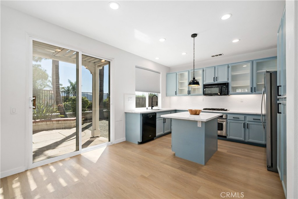 33307 Decada Street Temecula, CA 92592 - Photo 8 of 35 a large kitchen with kitchen island a large counter top space a sink stainless steel appliances and cabinets