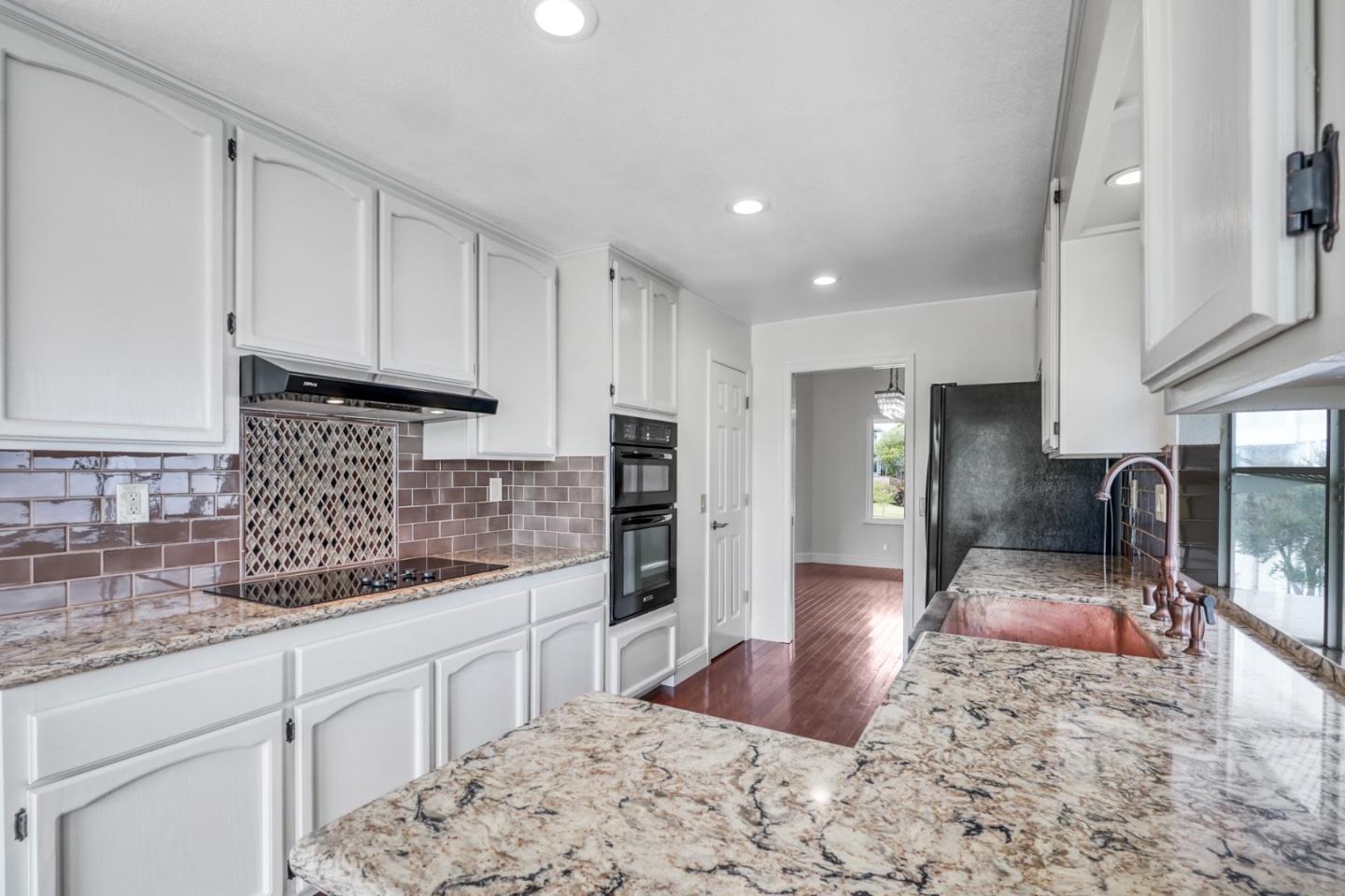 190 Cypress Point Road Half Moon Bay, CA 94019 - Photo 13 of 55 a kitchen with stainless steel appliances granite countertop a stove a sink a refrigerator and white cabinets