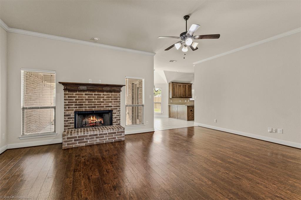 144 Birdsong Lane Terrell, TX 75160 - Photo 6 of 28 an empty room with wooden floor fireplace cabinet and windows