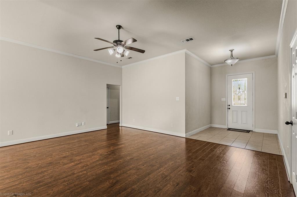 144 Birdsong Lane Terrell, TX 75160 - Photo 8 of 28 an empty room with wooden floor ceiling fan and windows