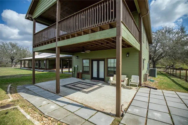 a kitchen with stainless steel appliances granite countertop a refrigerator a sink a stove and a dining table with wooden floor