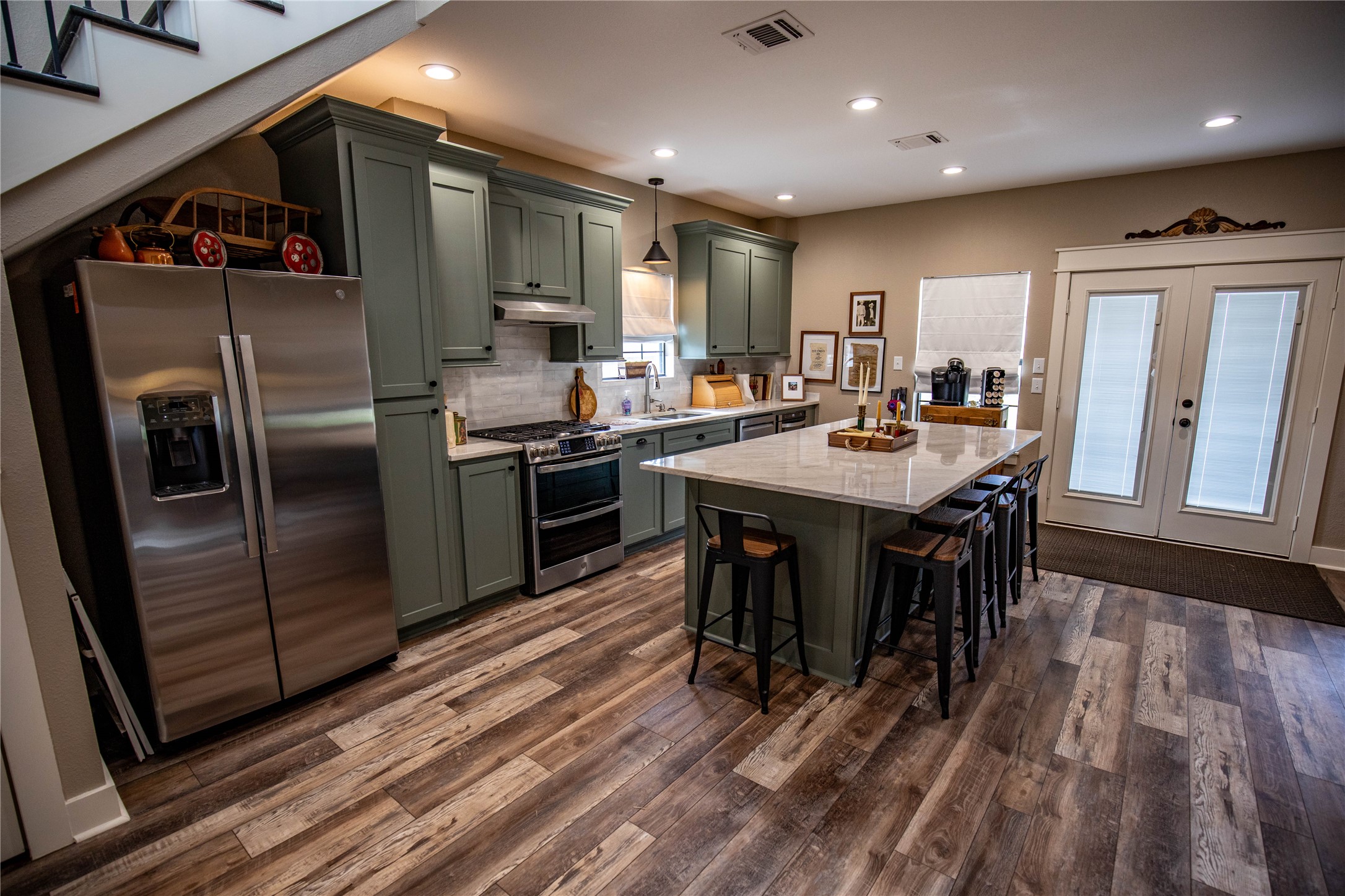 698 Hilbrich Road Westhoff, TX 77994 - Photo 36 of 40 a kitchen with stainless steel appliances granite countertop a refrigerator a sink a stove and a dining table with wooden floor