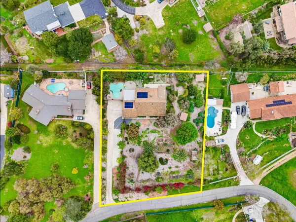 a view of backyard of house with wooden fence