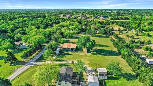 an aerial view of residential houses with outdoor space and trees