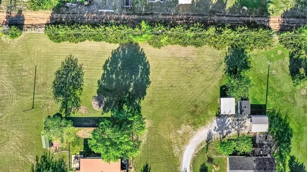 an aerial view of residential houses with outdoor space and trees