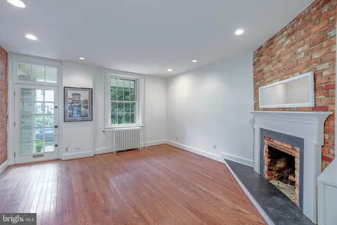 a view of empty room with wooden floor and fireplace