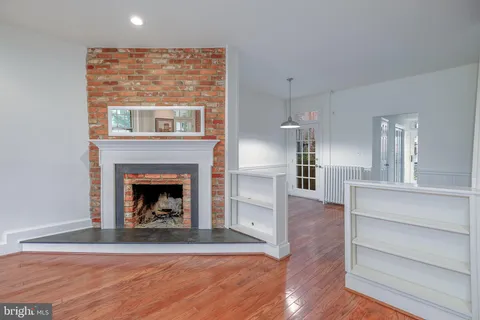 a living room with wooden floor and a fireplace