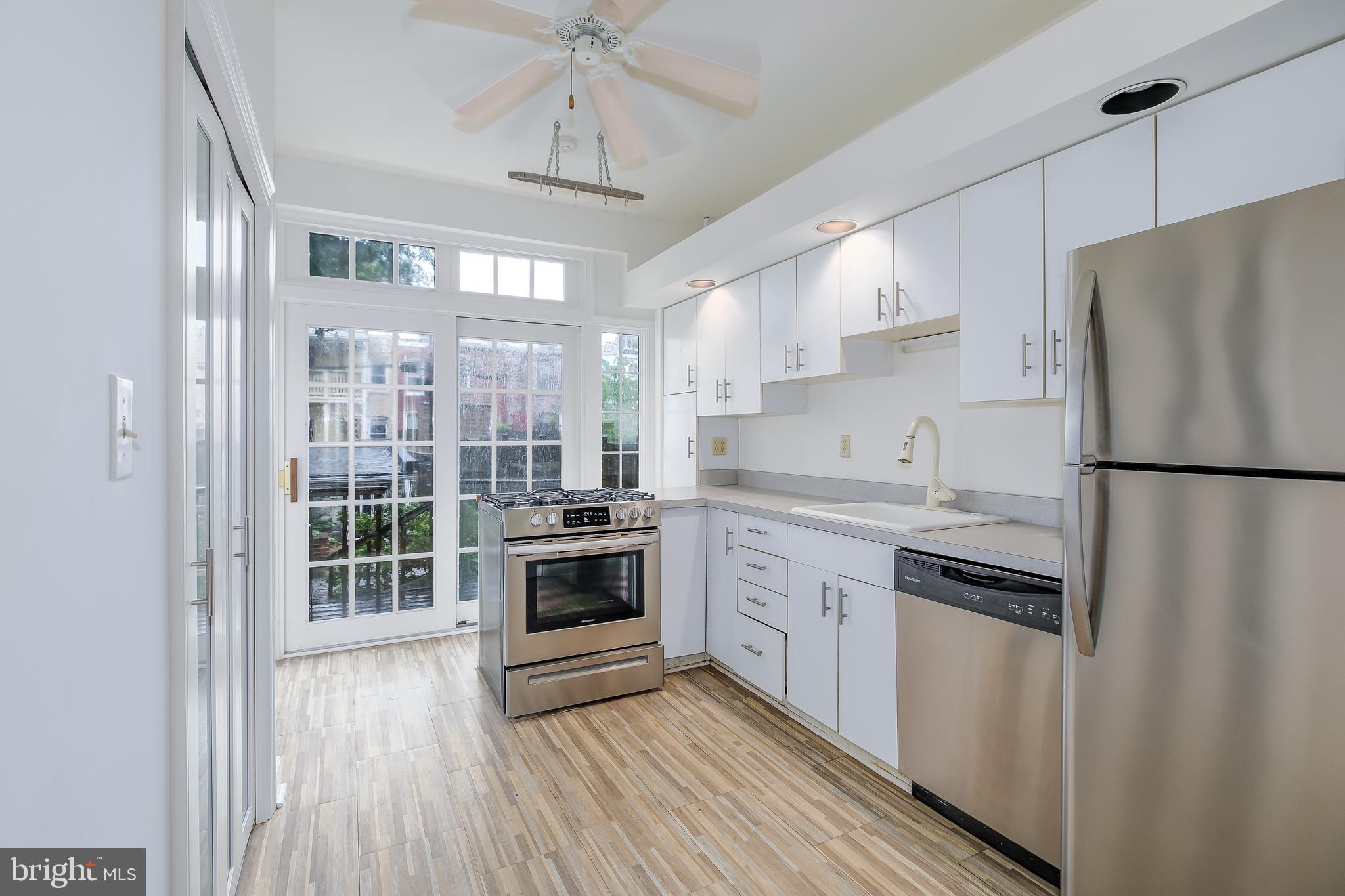 323 14th Street Northeast Washington, DC 20002 - Photo 17 of 41 a kitchen with stainless steel appliances granite countertop a refrigerator a sink dishwasher a stove and white countertops with wooden floor