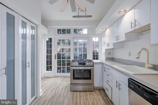 a kitchen with stainless steel appliances granite countertop a stove and cabinets