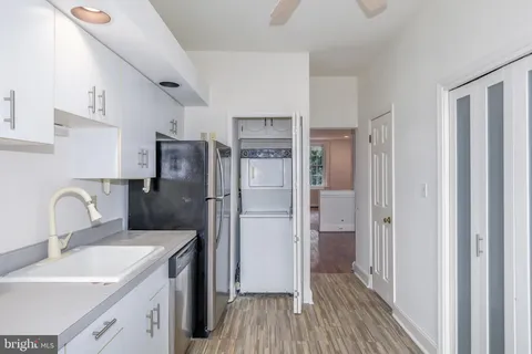 a kitchen with a refrigerator sink and cabinets