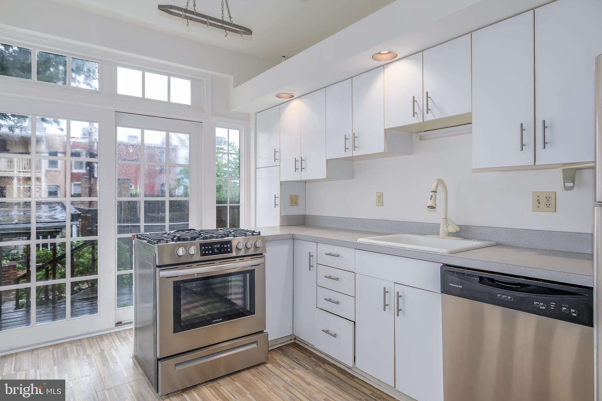 323 14th Street Northeast Washington, DC 20002 - Photo 21 of 41 a kitchen with stainless steel appliances granite countertop a stove a sink and white cabinets