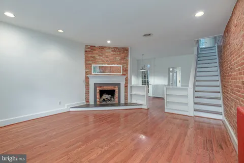 a view of empty room with wooden floor and fireplace