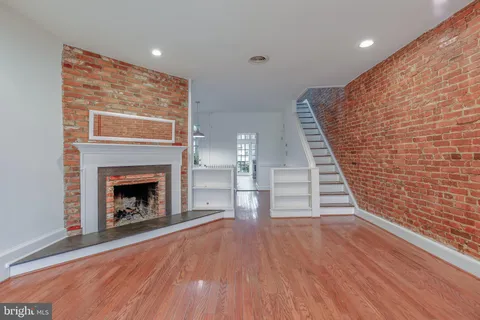 a view of a livingroom with wooden floor and a fireplace