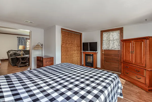 a bedroom with a bed and wooden floor