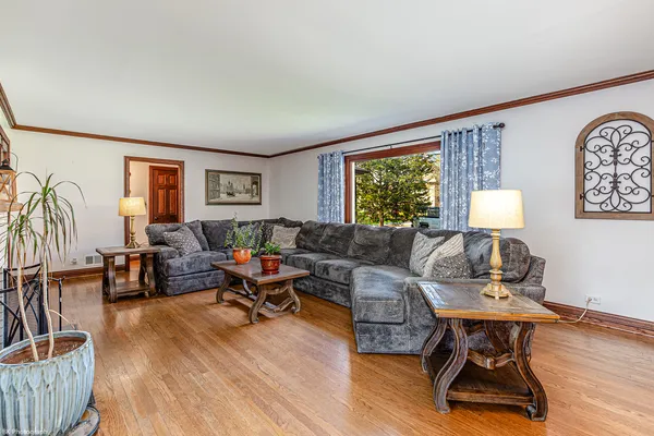 a living room with furniture floor to ceiling window and wooden floor