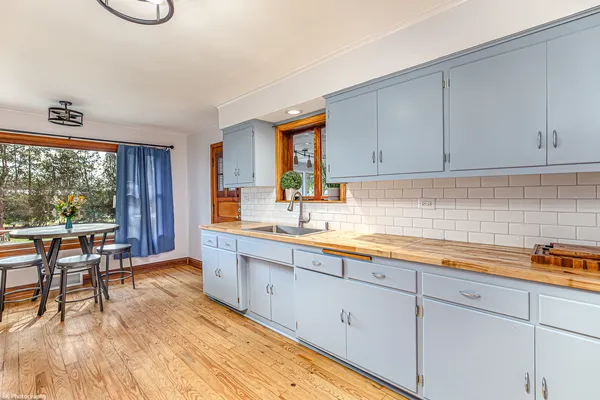 a kitchen with stainless steel appliances granite countertop a sink a stove and wooden floors