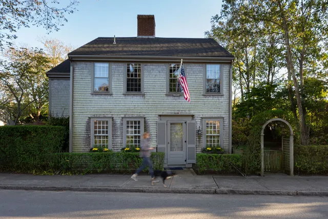 a front view of a house with garage and plants