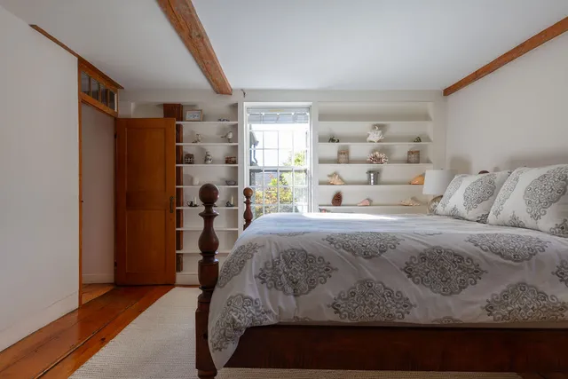 a bed sitting in a bedroom next to a window