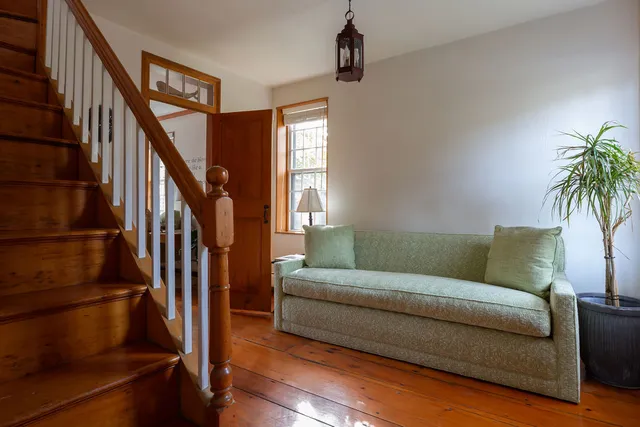 a living room with furniture and a potted plant on a bookshelf