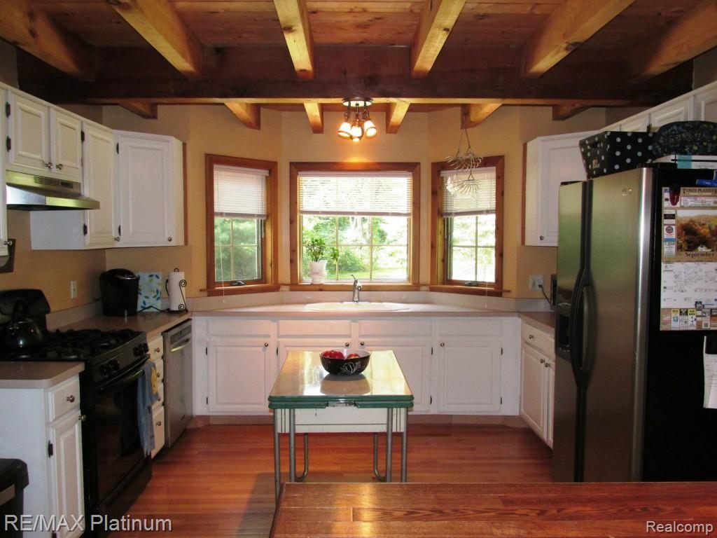 12296 Rohn Road Fenton, MI 48430 - Photo 13 of 38 KITCHEN W/WHITE CABINETS, HARDWOOD FLOORS & BAY WINDOW