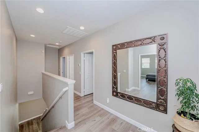 a view of a hallway with wooden floor and staircase