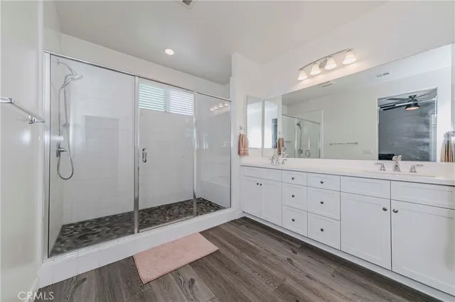 a spacious bathroom with a shower sink and mirror