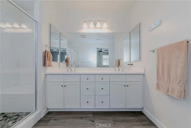 a bathroom with a granite countertop sink mirror and cabinets