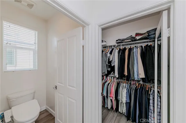 a view of walk in closet with clothes and shoes