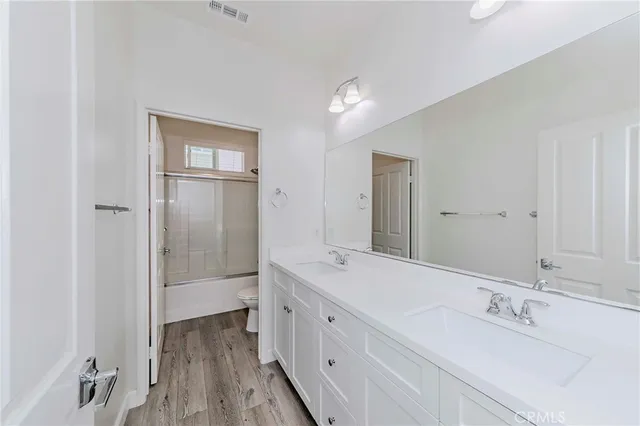 a spacious bathroom with a double vanity sink and mirror