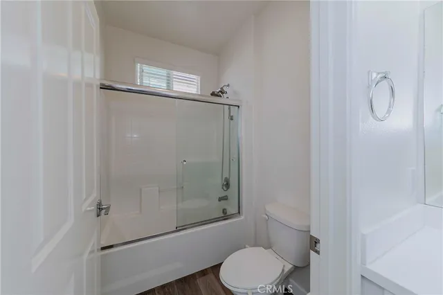 a bathroom with a granite countertop toilet and a shower