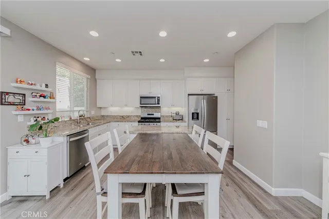 a large kitchen with granite countertop a center island and stainless steel appliances