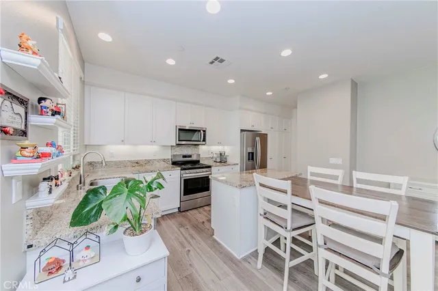 a kitchen with white cabinets and appliances