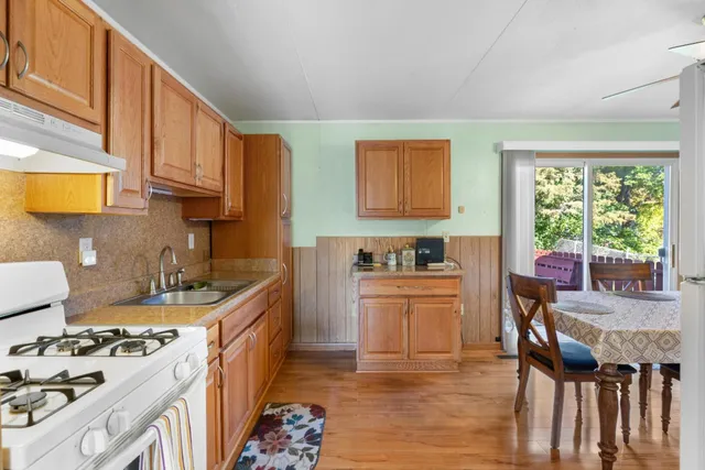 a kitchen with stainless steel appliances a stove a sink dishwasher and cabinets with wooden floor