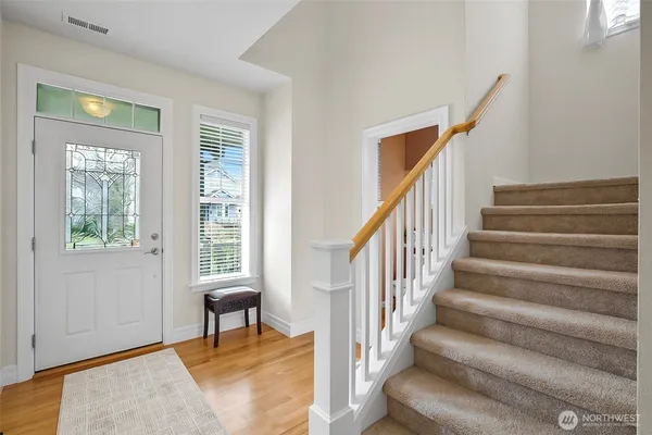 a view of a hallway with wooden floor and staircase