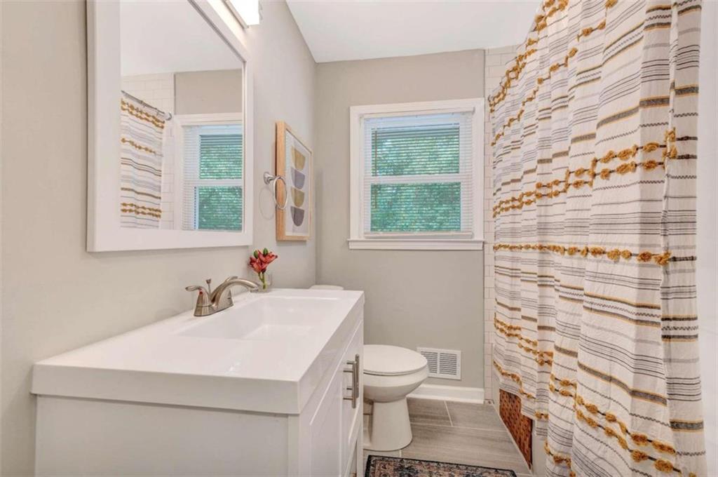 1376 Sandtown Road Southwest Marietta, GA 30008 - Photo 21 of 25 a bathroom with a sink toilet and window
