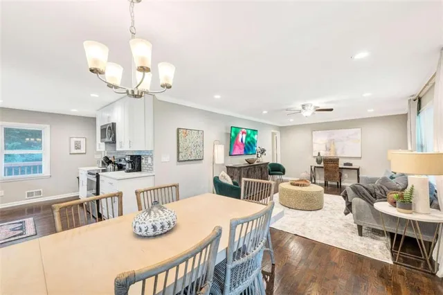 a view of a dining room with furniture a chandelier and wooden floor