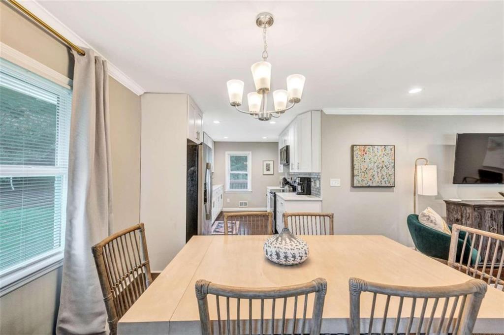 1376 Sandtown Road Southwest Marietta, GA 30008 - Photo 9 of 25 a view of a dining room with furniture a chandelier and wooden floor