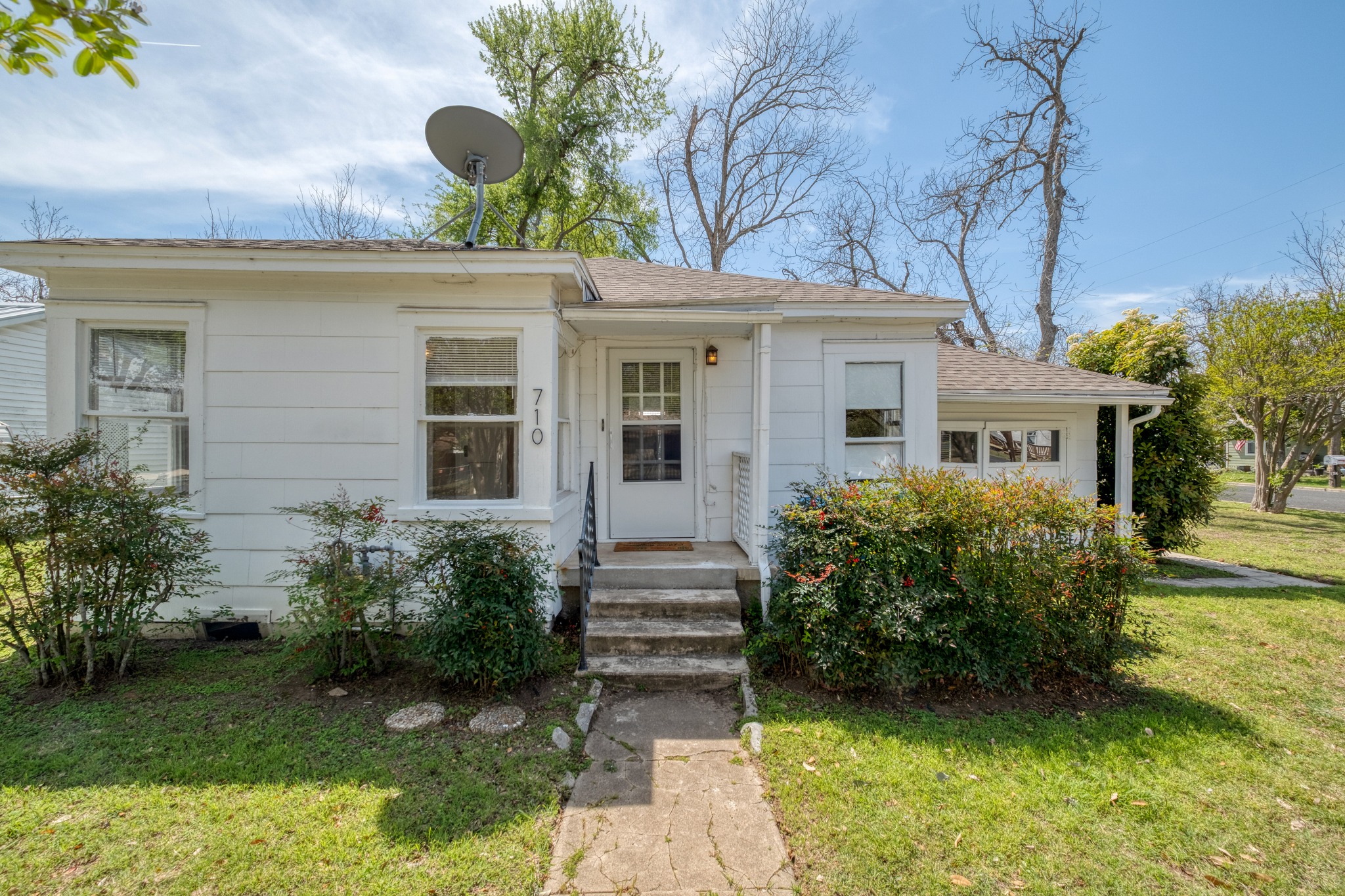 Front of home from sidewalk with steps up to front entry porch