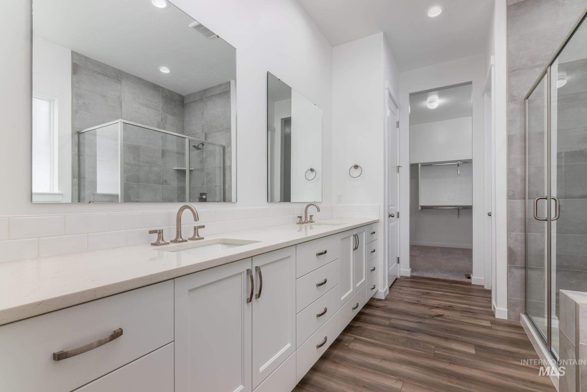 15232 Steel Cloud Avenue Caldwell, ID 83607 - Photo 18 of 33 Full bath featuring double vanity, a stall shower, dark wood-type flooring, a walk in closet, and recessed lighting