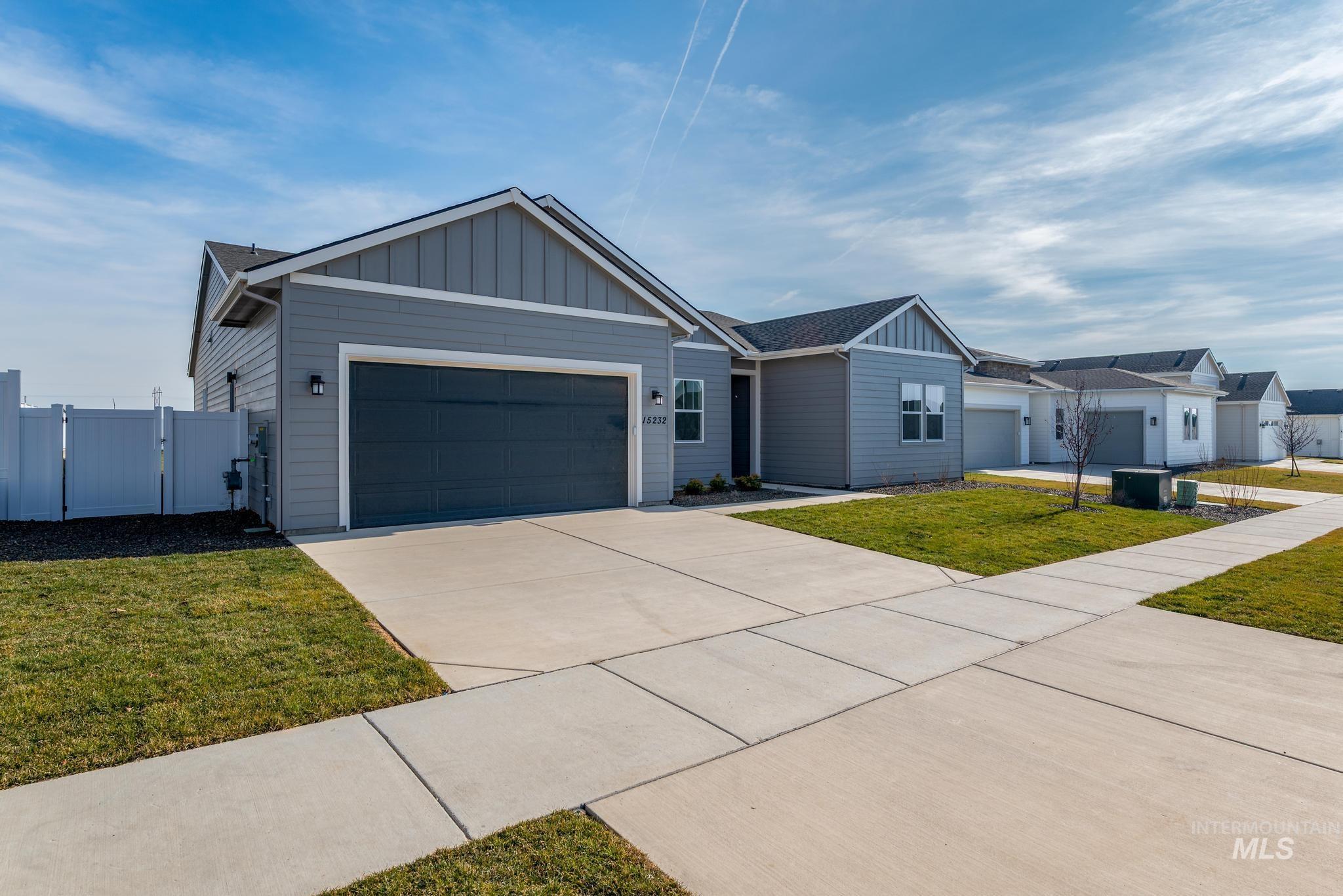 15232 Steel Cloud Avenue Caldwell, ID 83607 - Photo 2 of 33 Ranch-style house with board and batten siding, a gate, an attached garage, and driveway