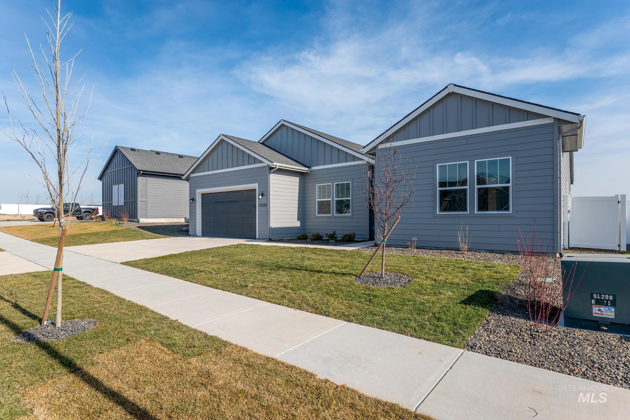 15232 Steel Cloud Avenue Caldwell, ID 83607 - Photo 3 of 33 Single story home with board and batten siding, a front yard, driveway, and a garage