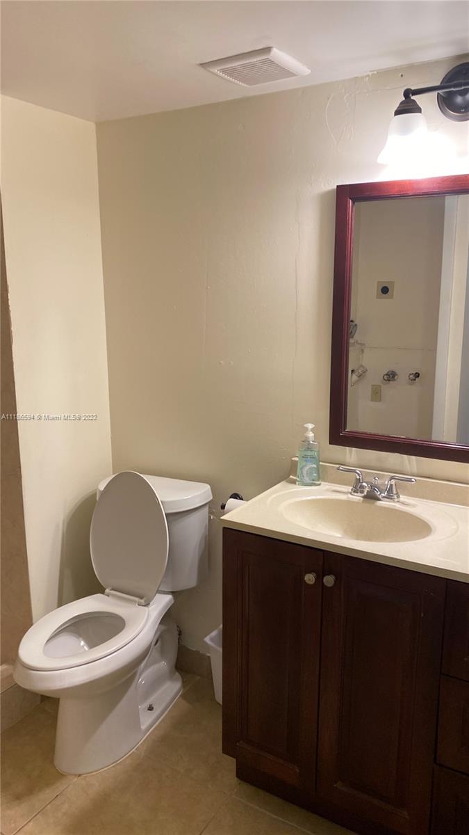 360 Racquet Club Road, Unit 201 Weston, FL 33326 - Photo 4 of 6 a bathroom with a toilet a sink and mirror